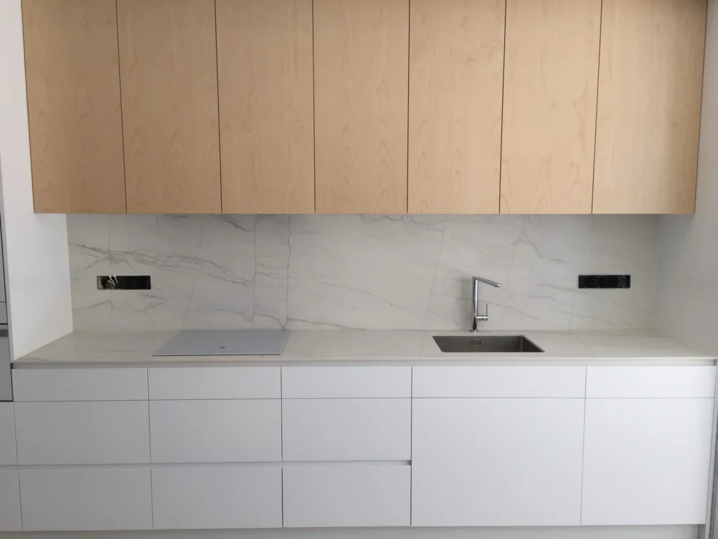 Cocina blanca con frentes superiores en acabado roble