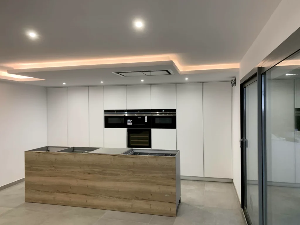 Cocina moderna blanca con isla revestida en madera
