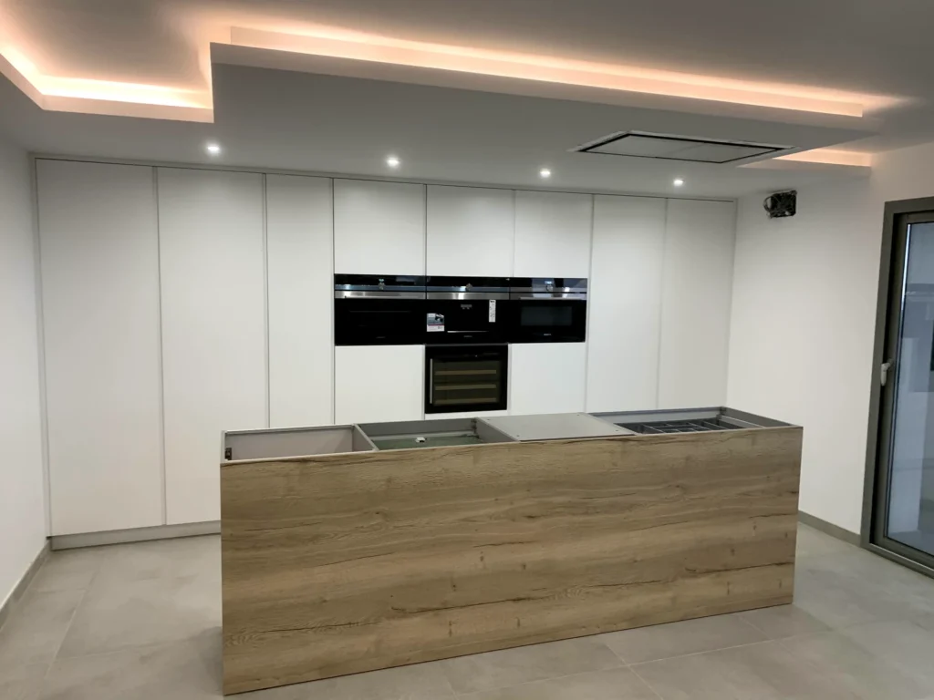 Cocina moderna blanca con isla revestida en madera