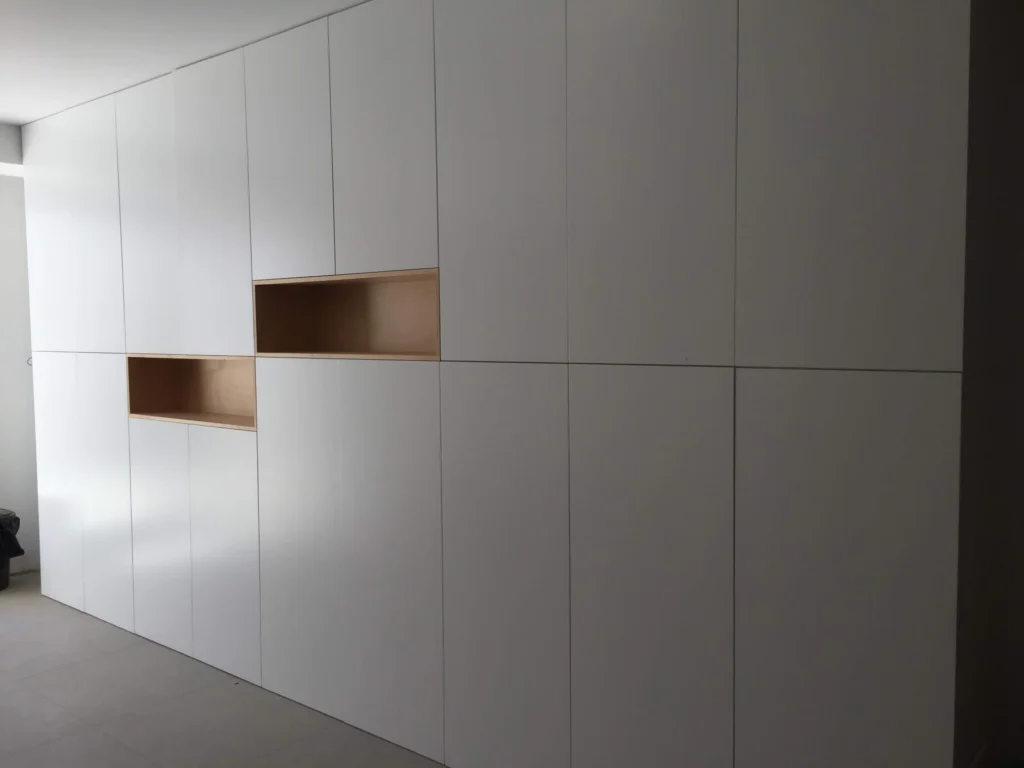 Mueble mural blanco a medida con nichos en madera