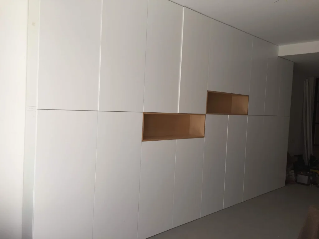 Mueble mural blanco a medida con nichos en madera